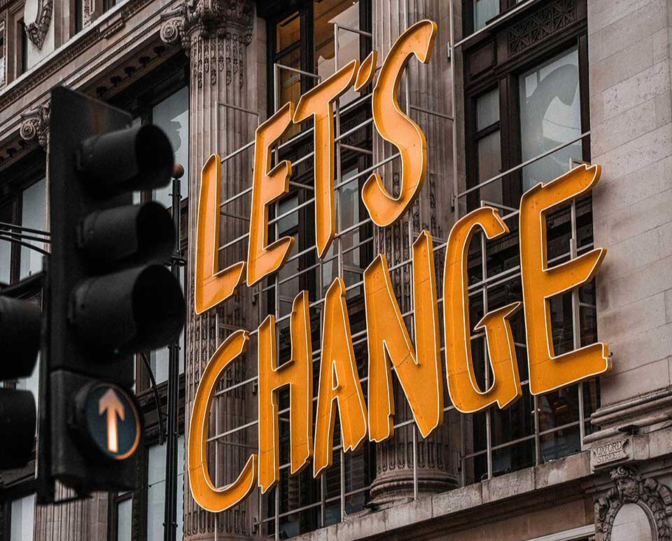 Change Management Visualisierung: Neon-Schriftzug "Let's Change" für Bürotransformation und Veränderungsprozesse